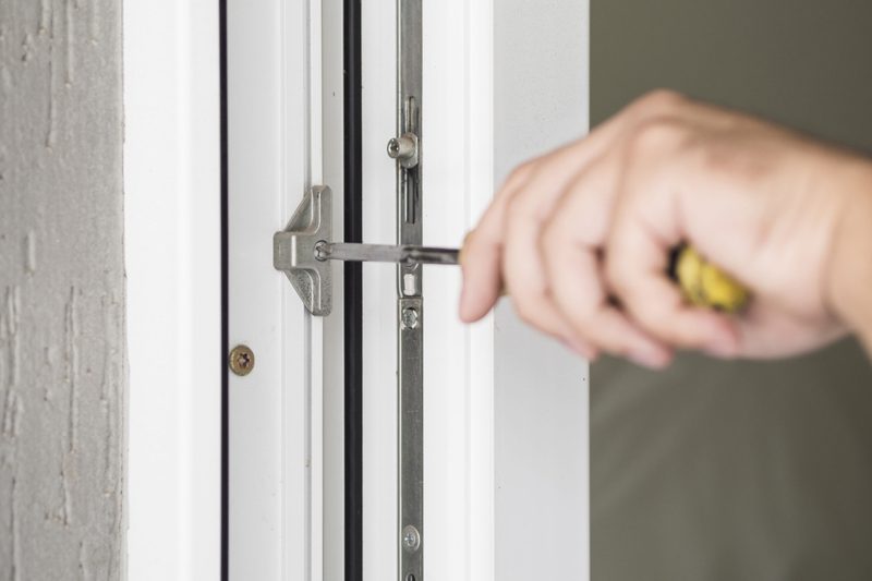 Einstellarbeiten am Fensterbeschlag